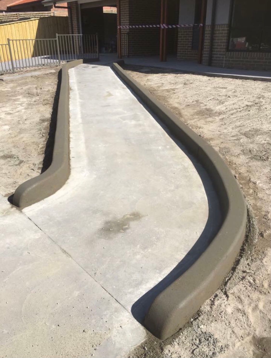 A Concrete Walkway is Being Built in Front of a House — Coastal Kerb and Concrete In Woy Woy, NSW