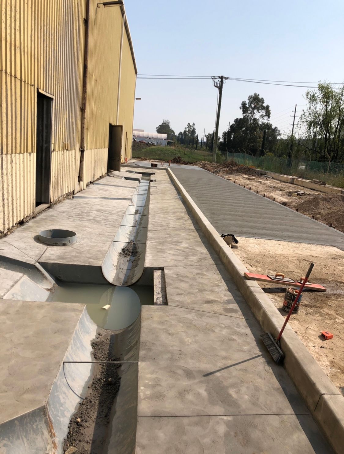 A Concrete Walkway is Being Built in Front of a Building — Coastal Kerb and Concrete In Buff Point, NSW