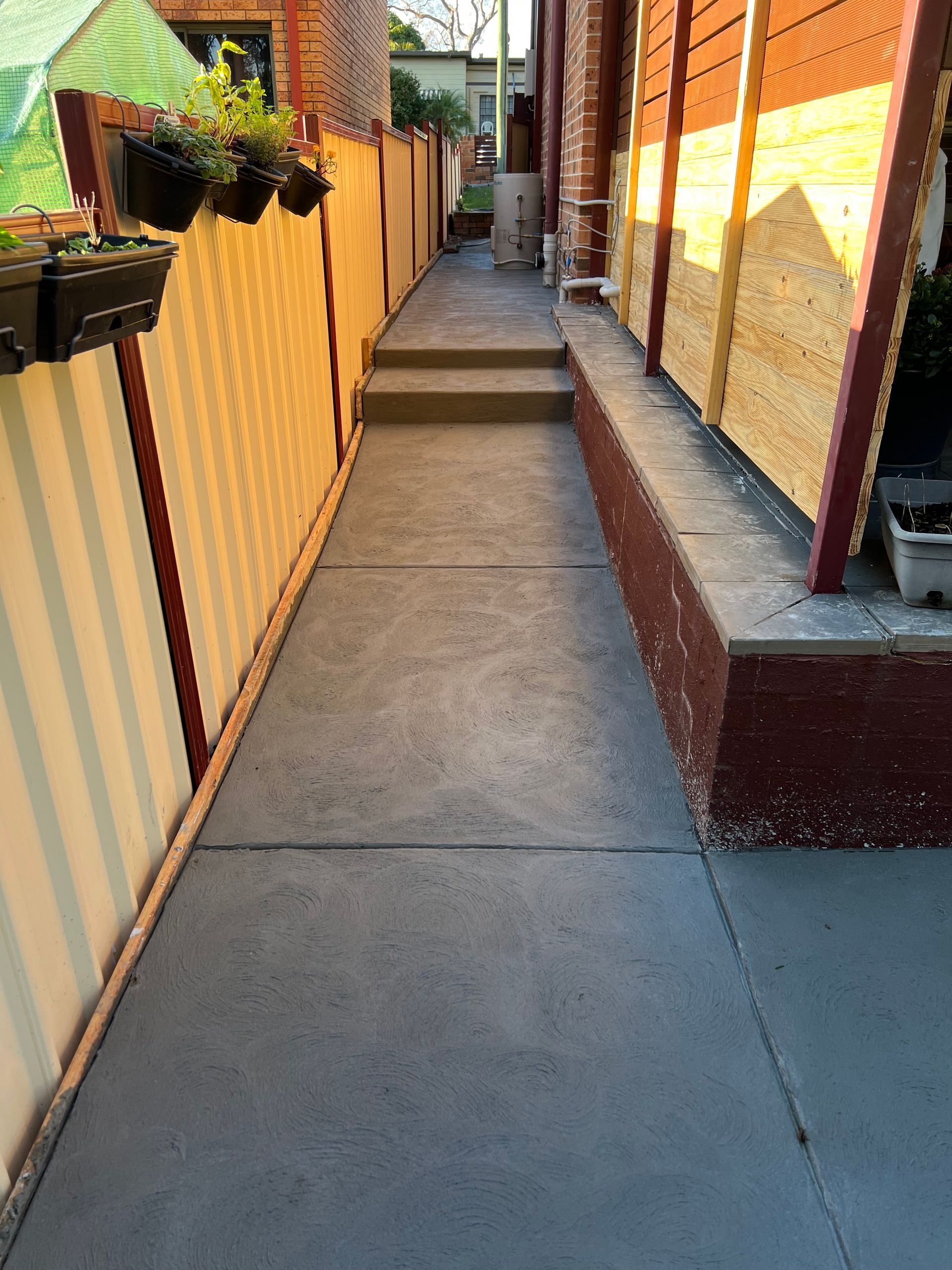 A Sidewalk Leading to a House With a Fence and Steps — Coastal Kerb and Concrete In Buff Point, NSW