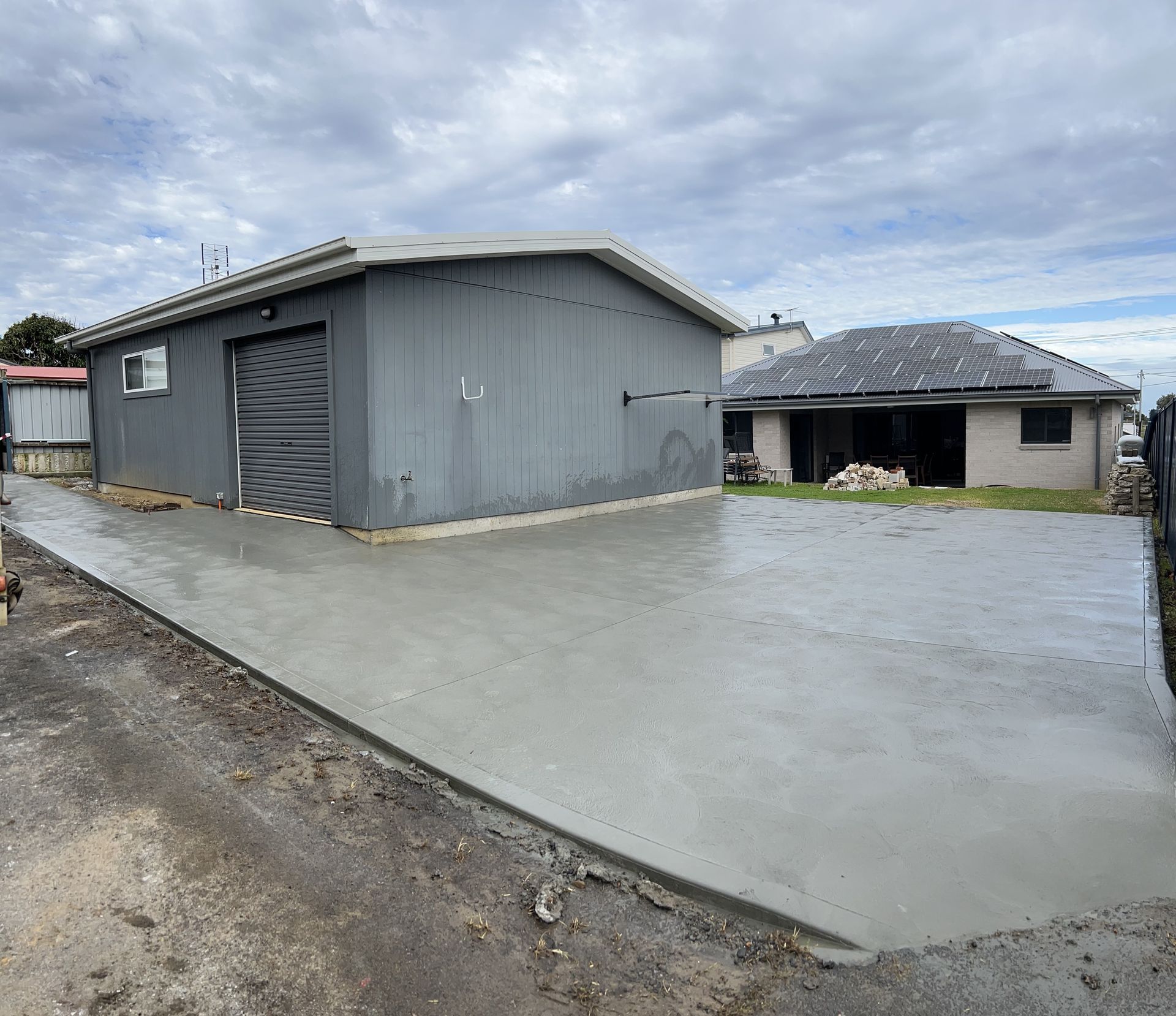 A House With a Garage and a Concrete Driveway in Front of It — Coastal Kerb and Concrete In Erina, NSW