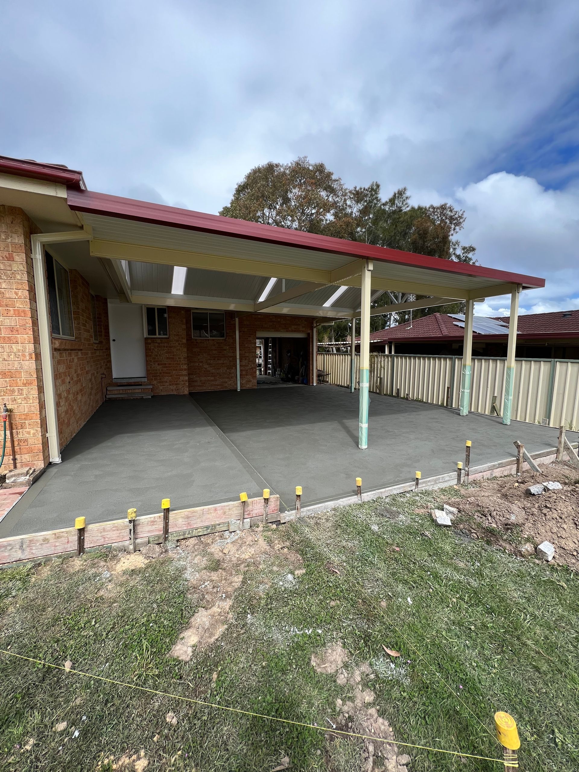 A Brick House With a Covered Driveway in Front of It — Coastal Kerb and Concrete In Buff Point, NSW