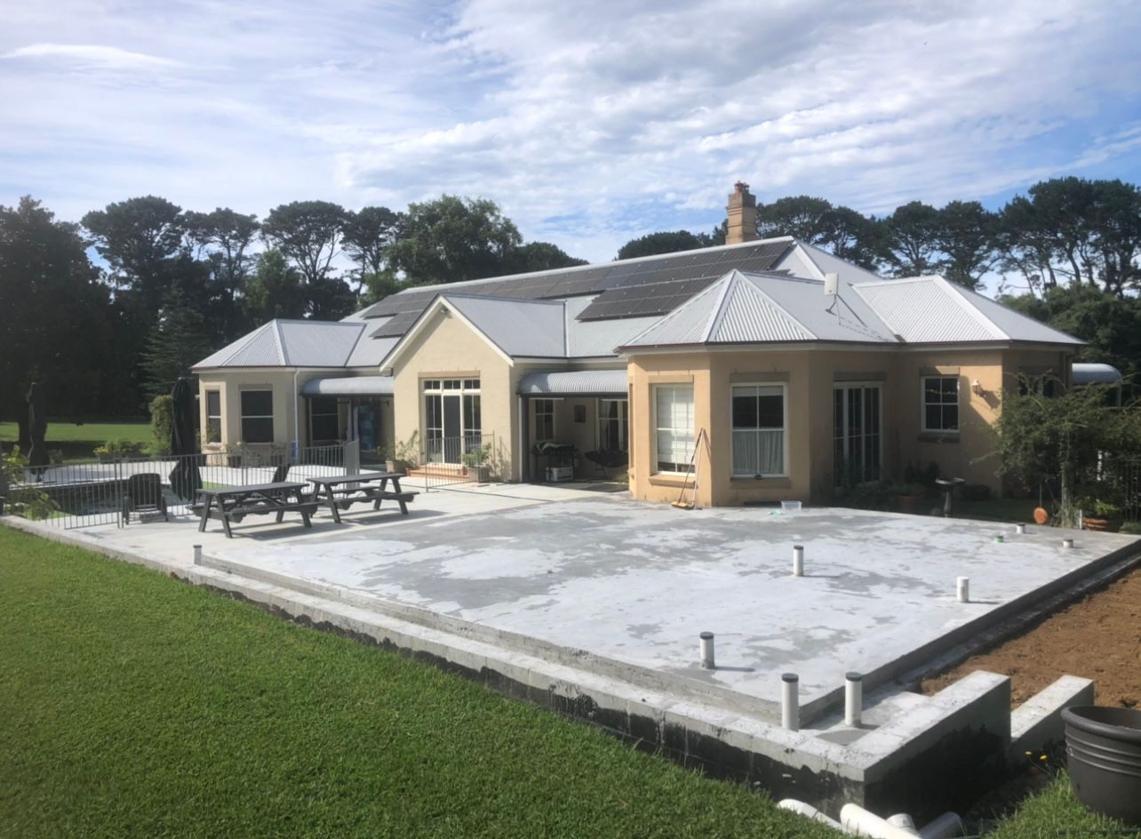 A Large House With a Concrete Patio in Front of It — Coastal Kerb and Concrete In Buff Point, NSW