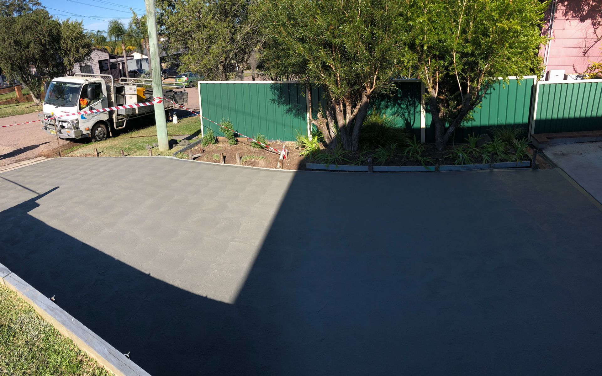 A Concrete Driveway is Being Built in Front of a House — Coastal Kerb and Concrete In Buff Point, NSW