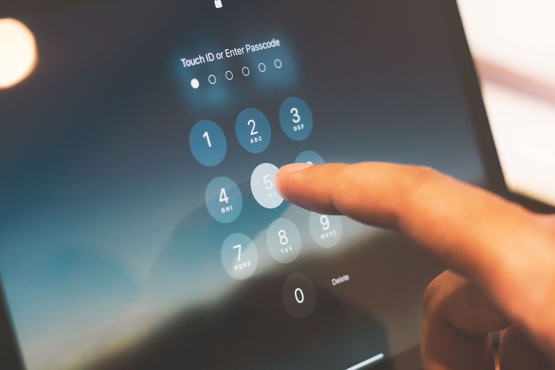 Dedo introduzindo PIN num teclado numérico touchscreen iluminado