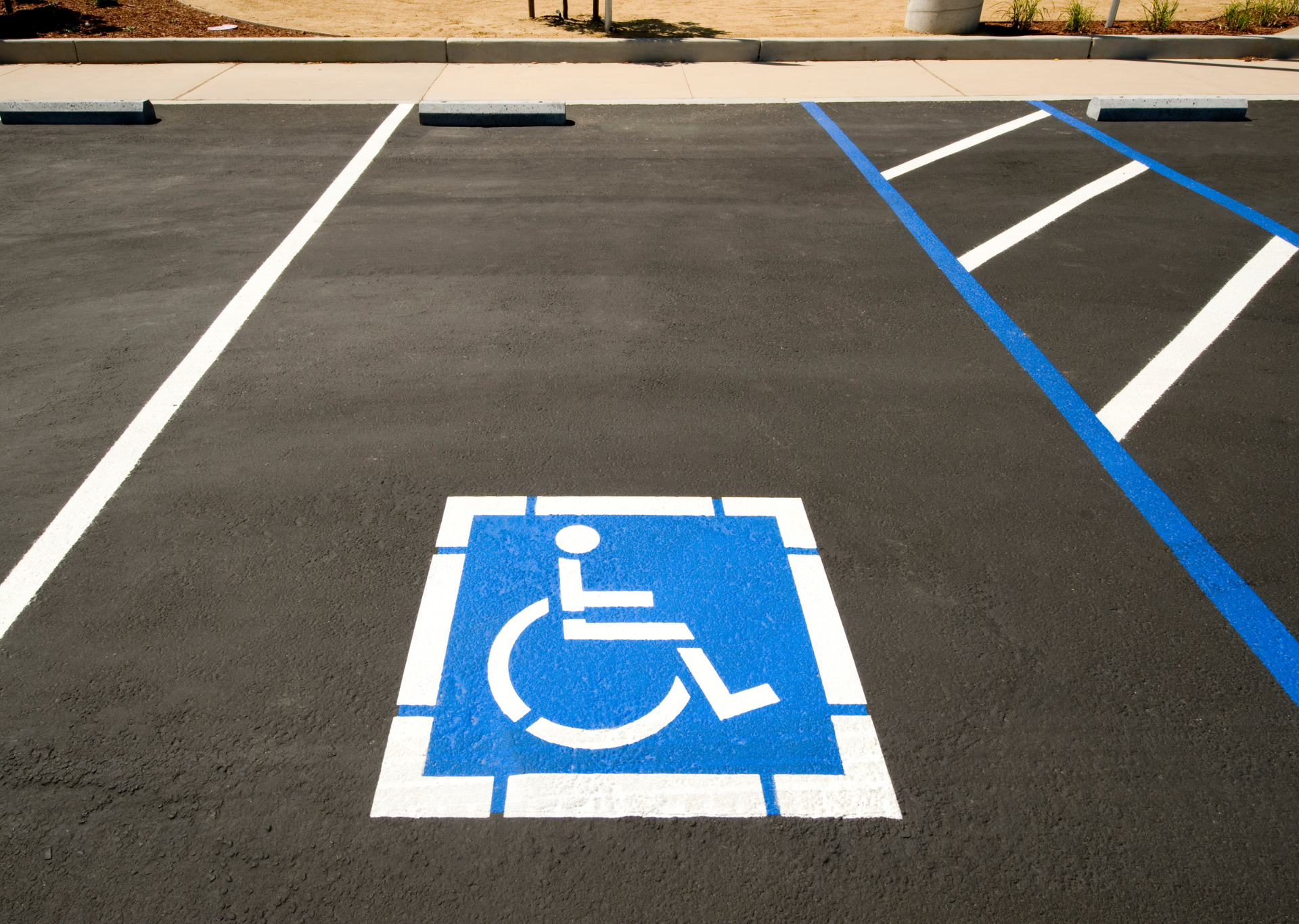 Disabled parking space with blue and white markings; wheelchair symbol.