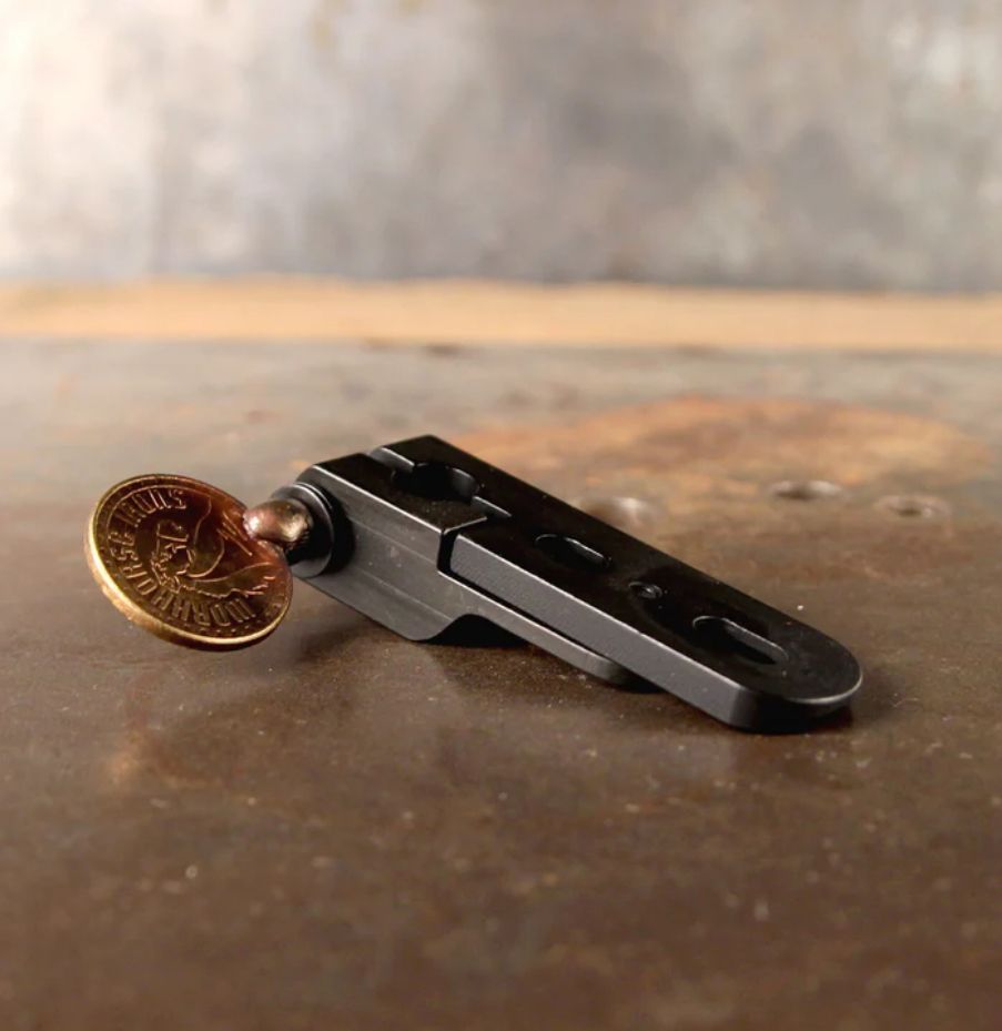 A coin is sitting on top of a metal object on a table.