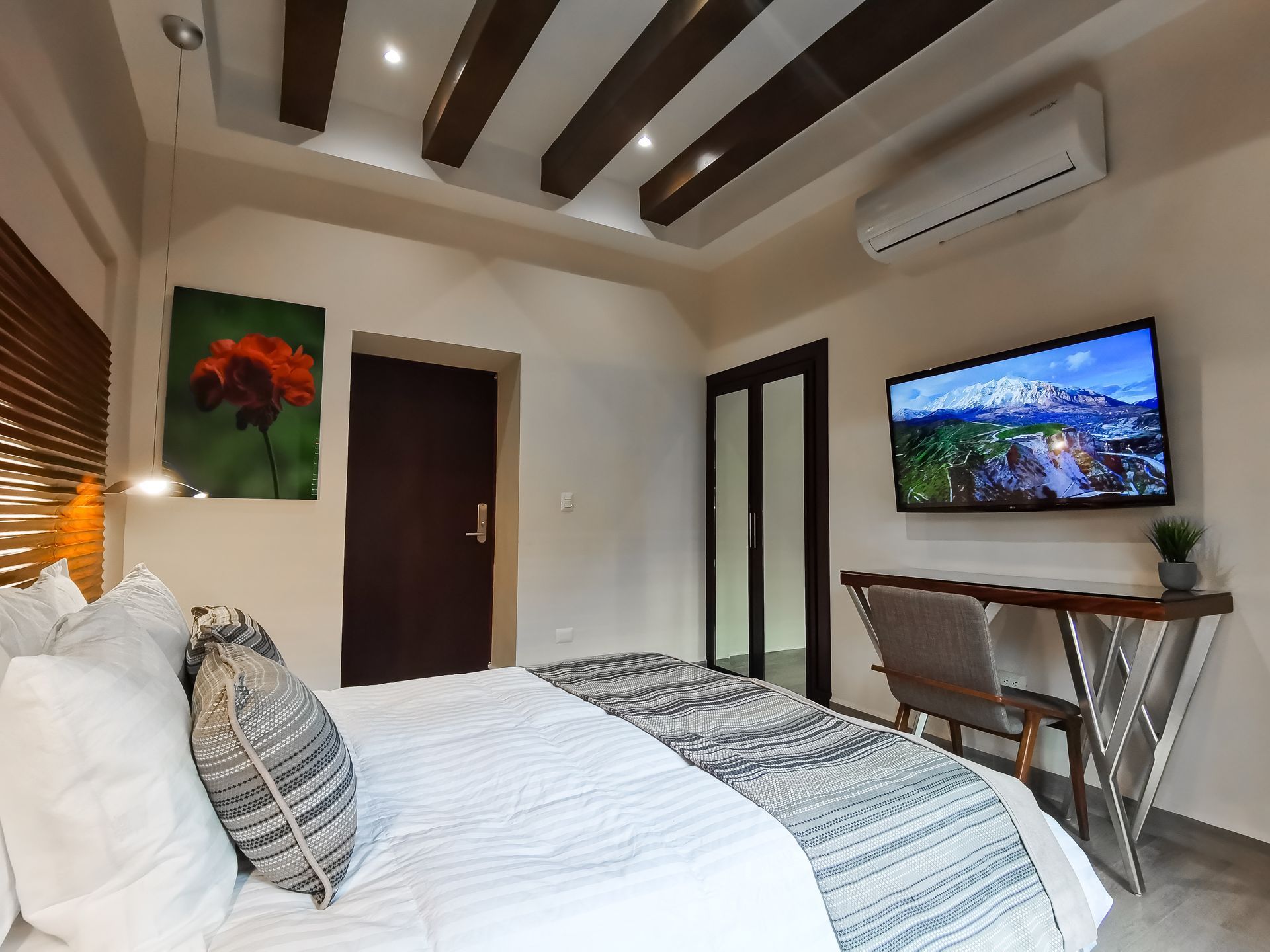Una habitación de hotel con cama, escritorio, silla y televisión.