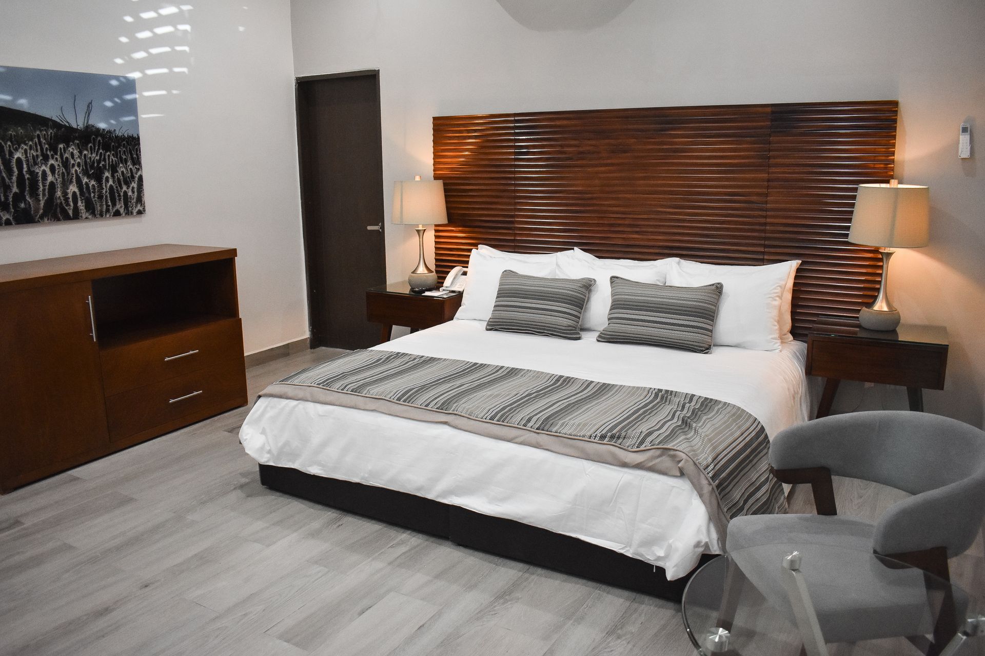 Una habitación de hotel con una cama tamaño king y una silla.
