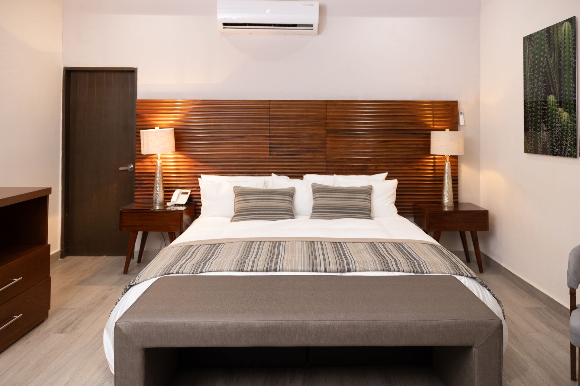 Una habitación de hotel con una cama tamaño king y un banco.