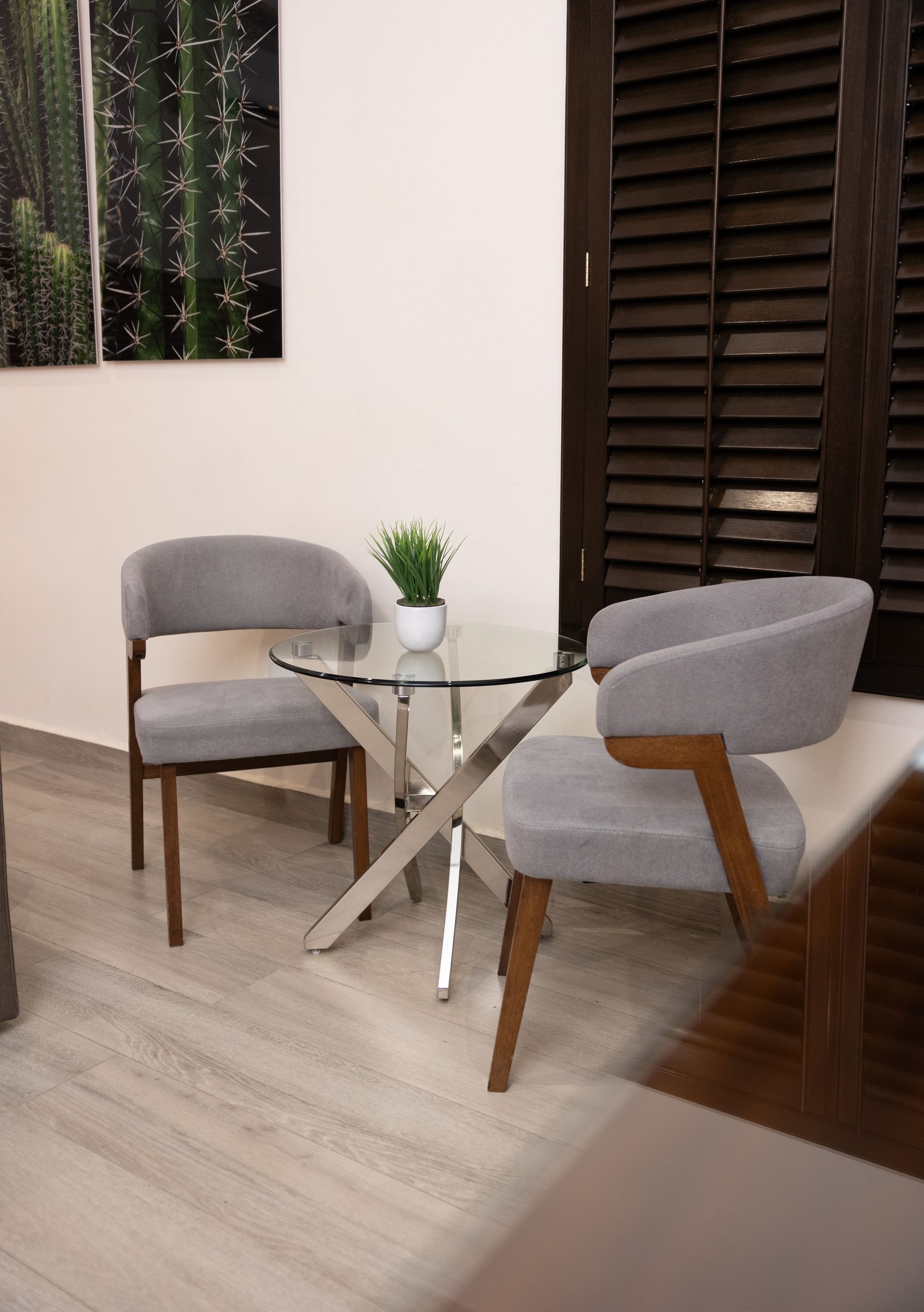 Una sala de estar con dos sillas y una mesa de cristal.