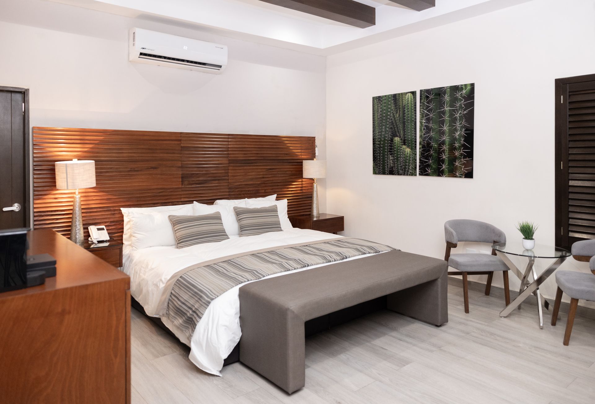 Una habitación de hotel con una cama tamaño king, sillas y una mesa.