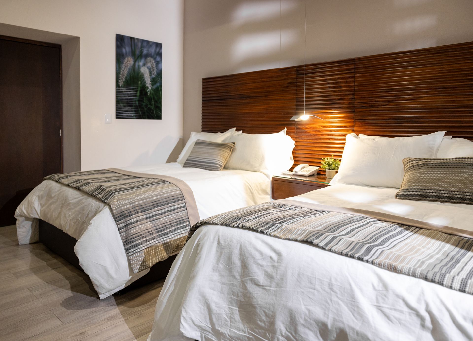 Una habitación de hotel con dos camas y un cuadro en la pared.