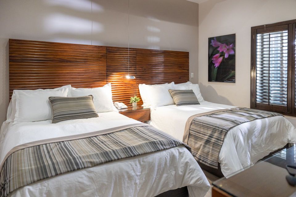 Una habitación de hotel con dos camas y un cuadro en la pared.