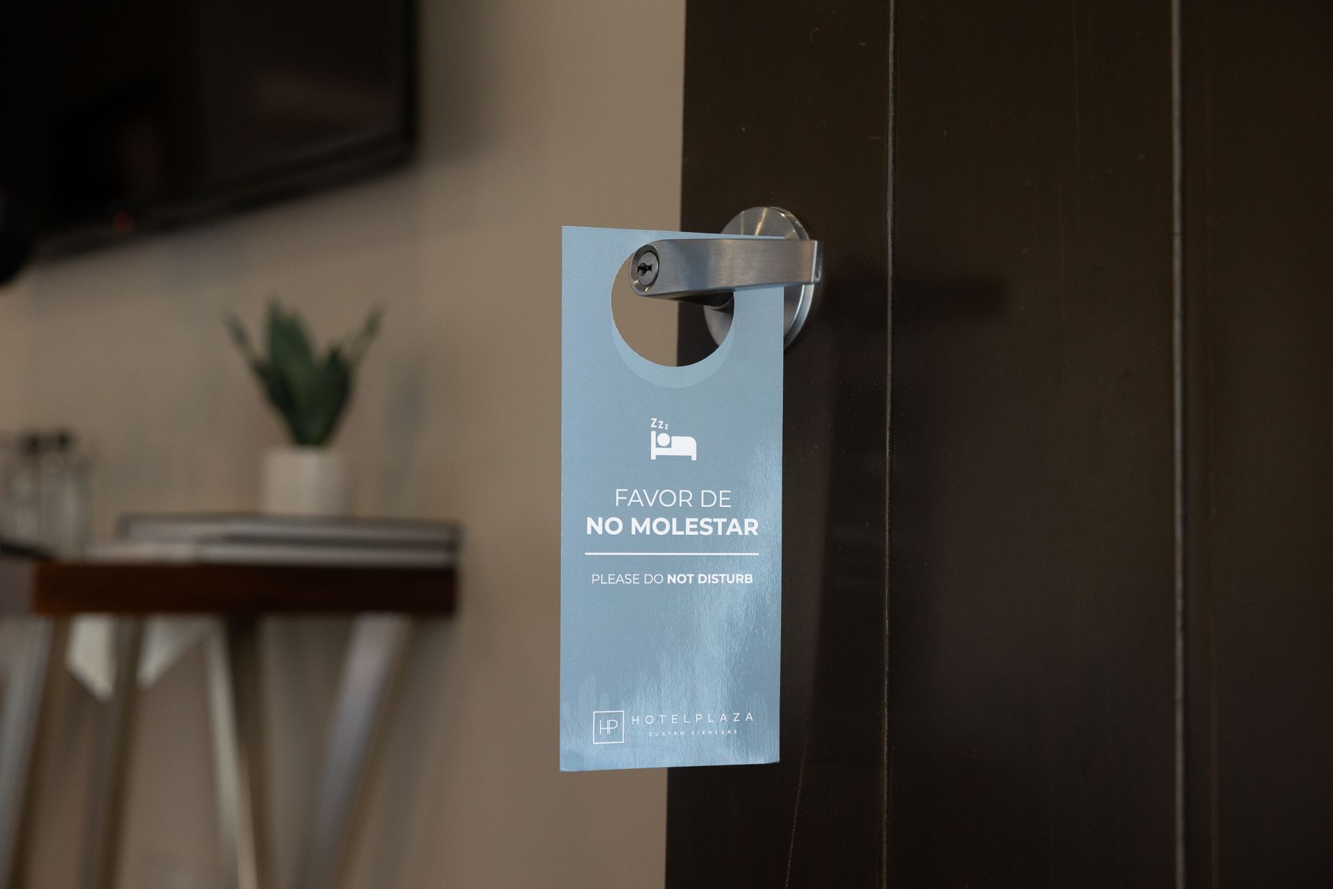 Un cartel de puerta está colgado en la puerta de una habitación de hotel.