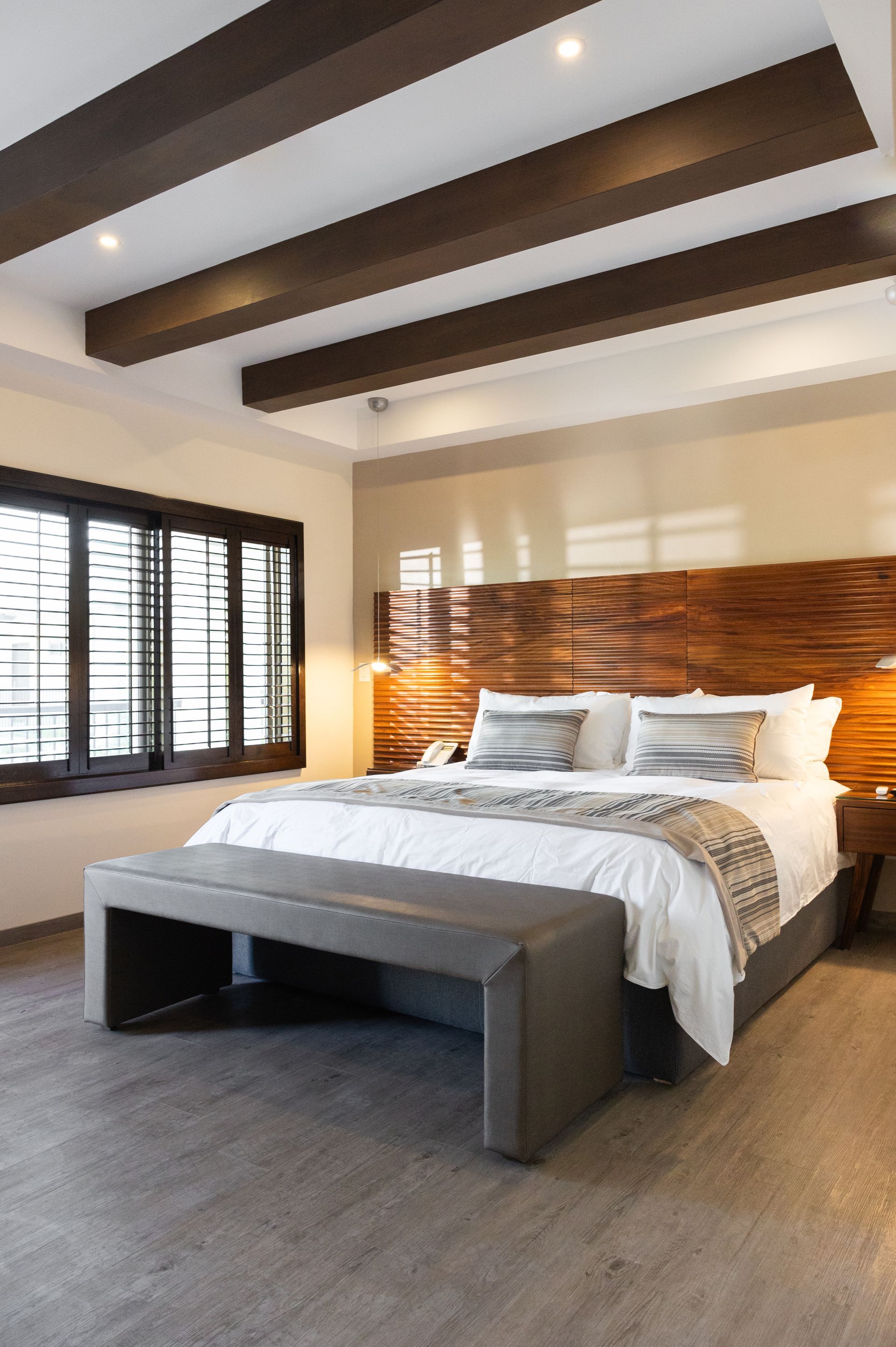 Un dormitorio con una cama king size y un banco.