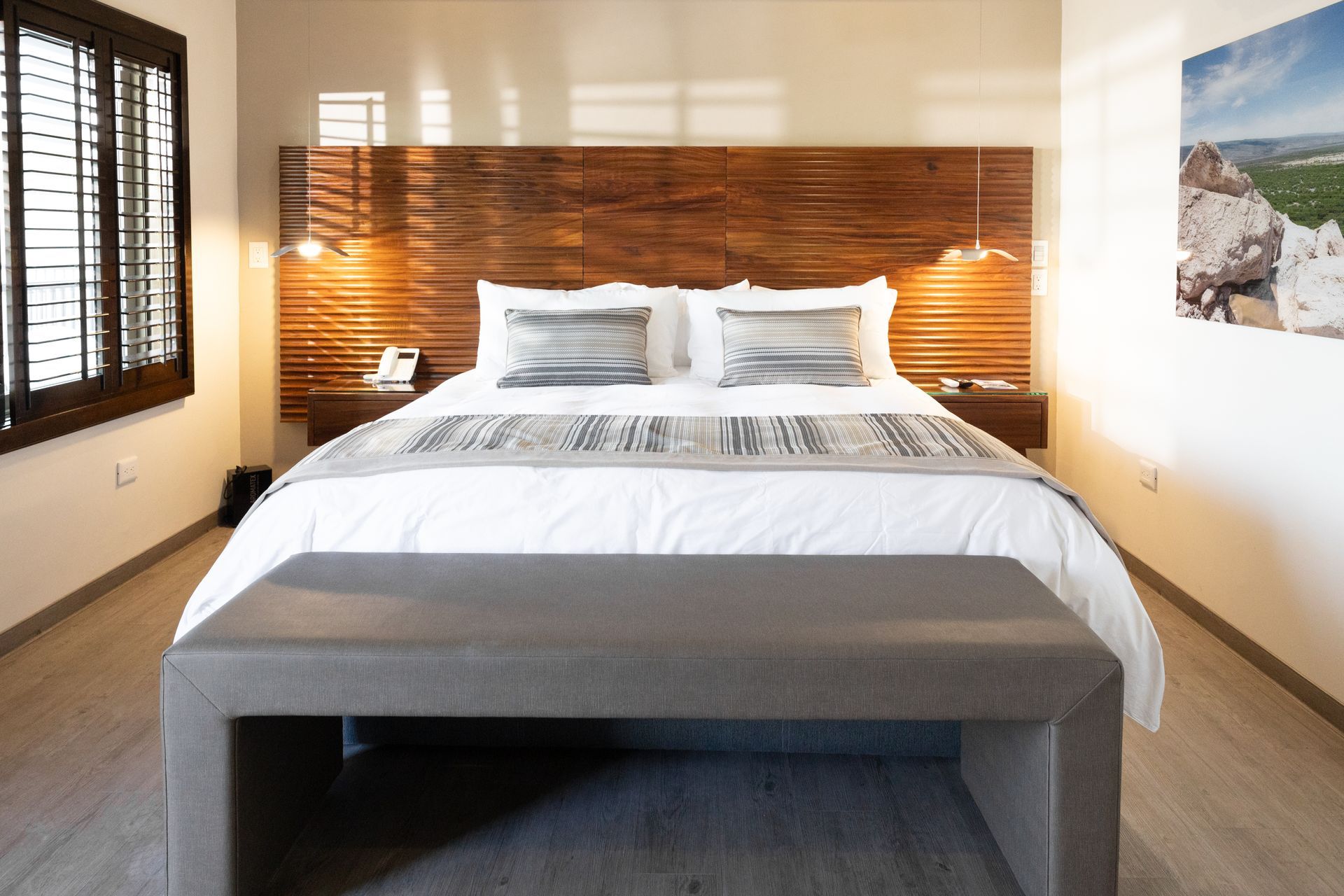 Una habitación de hotel con una cama grande y un banco.