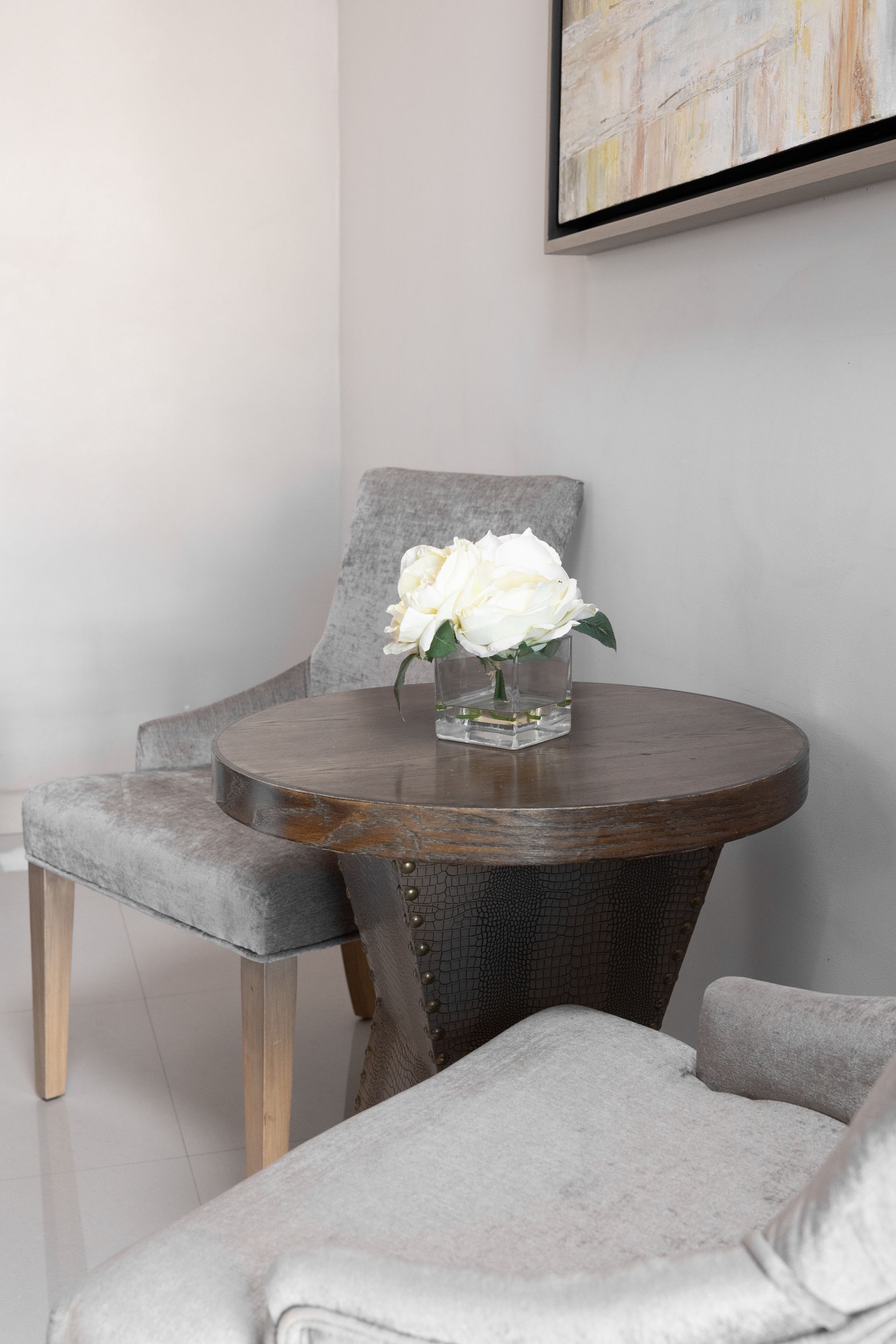 Una mesa con un jarrón de flores encima en una sala de estar.