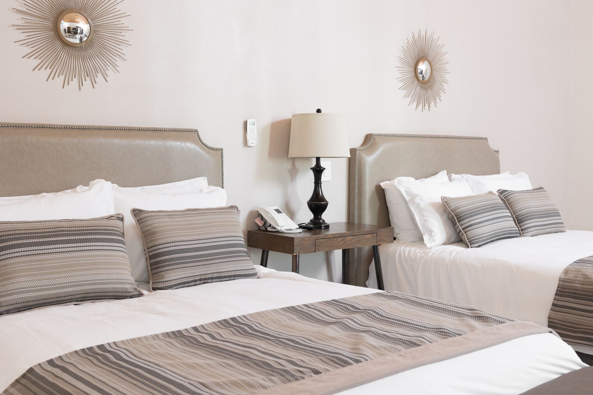Una habitación de hotel con dos camas y dos lámparas.