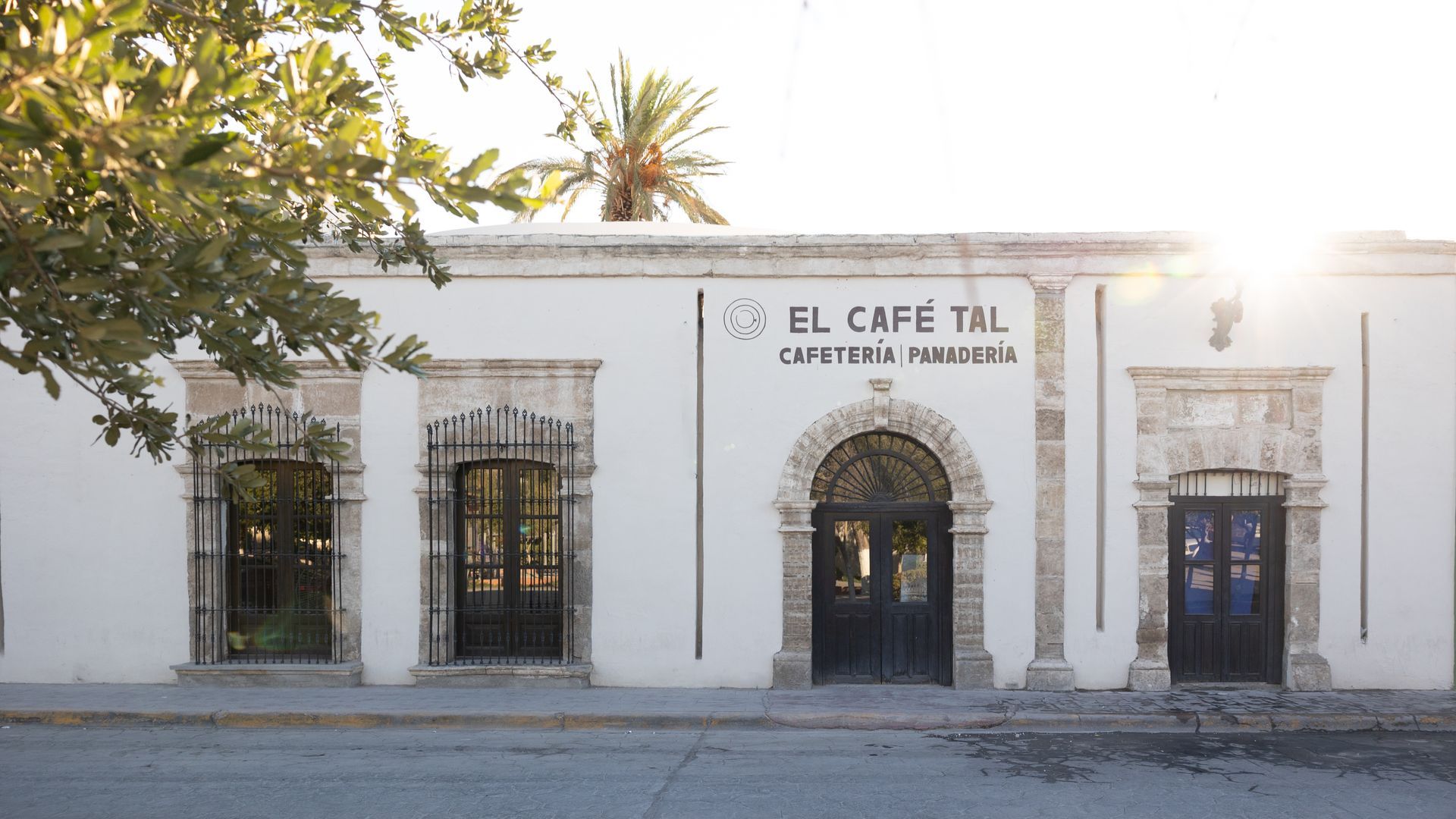 Un edificio blanco con un cartel que dice el cafe tal