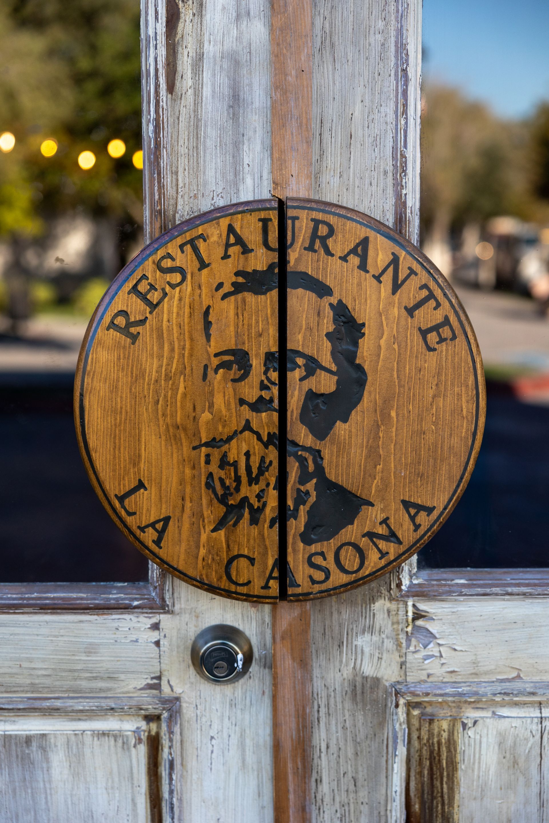 Un cartel de madera en una puerta que dice restaurante la casona