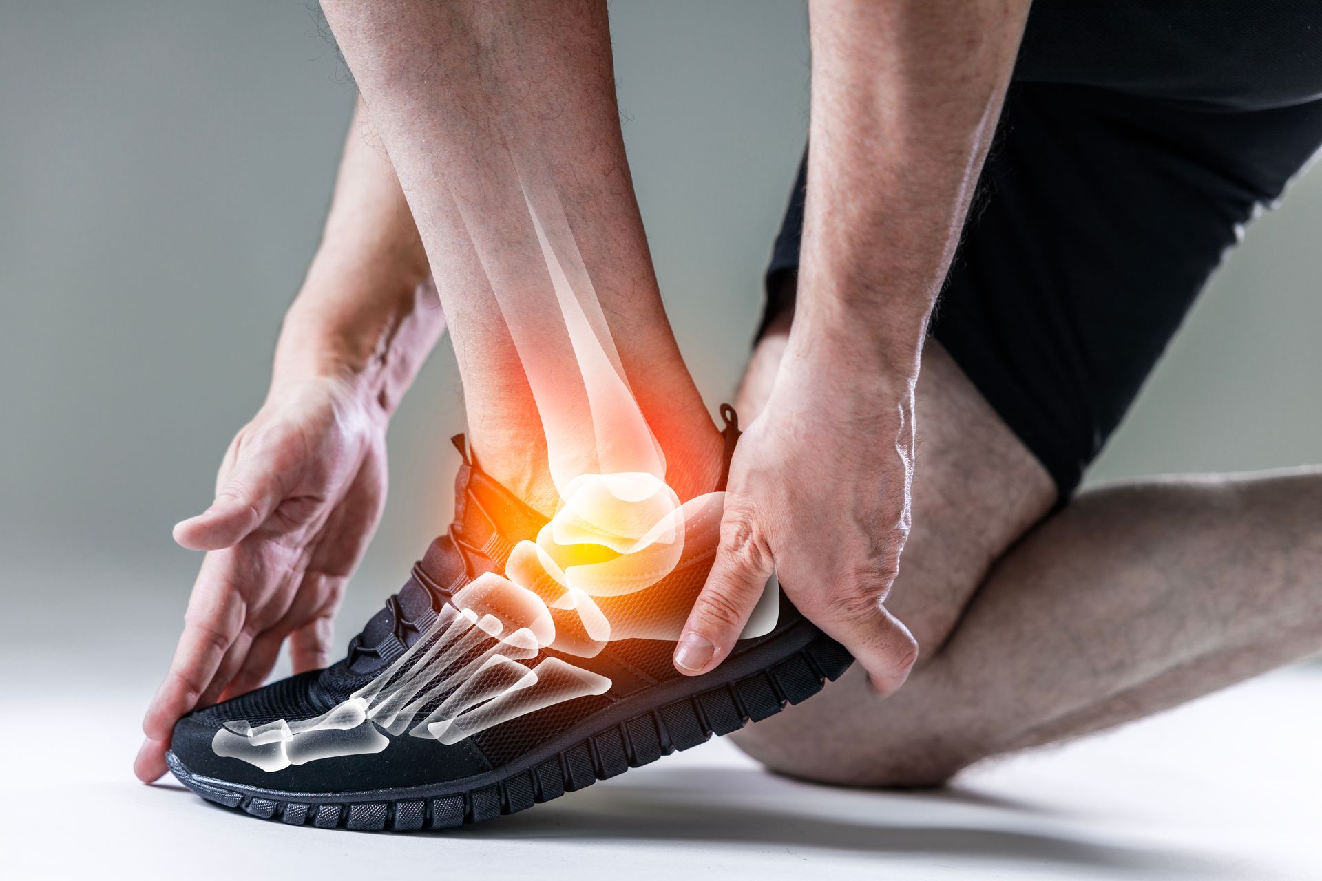 Man holding ankle in pain, highlighted bones in foot.