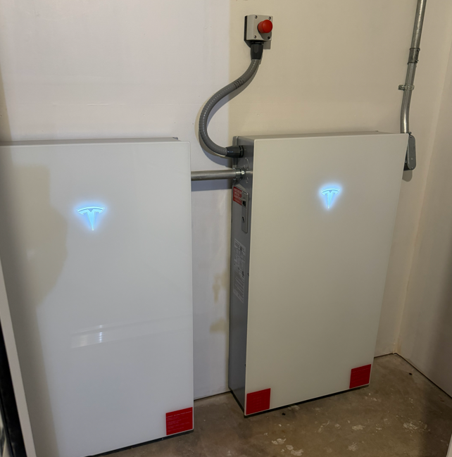 Electrical control box and bundled cables mounted on a wall in an industrial setting