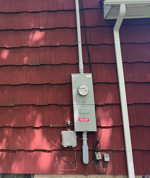 Row of white and gray electric utility meters mounted on a wall