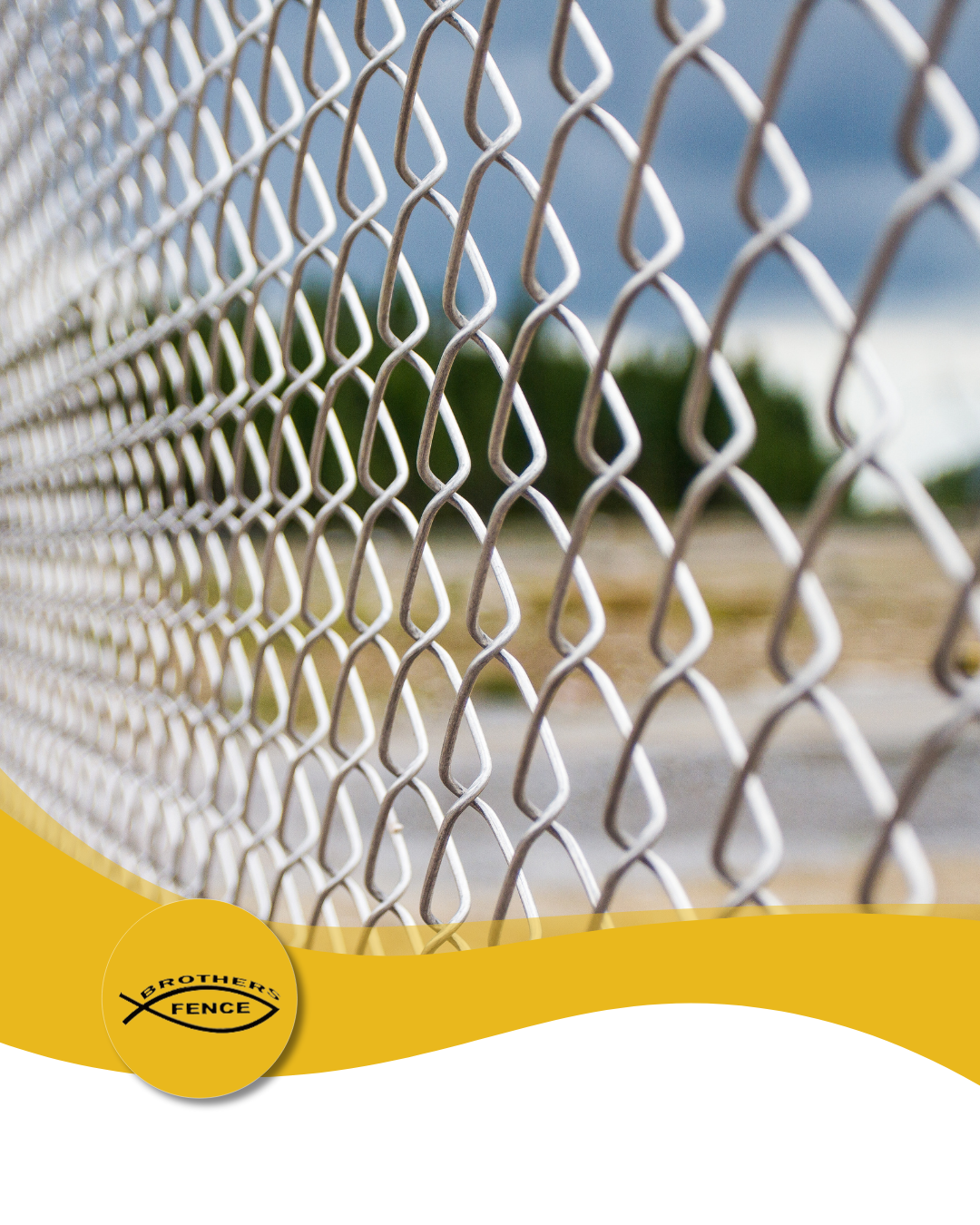 Chain-link fence, close-up, with blurry background of trees and sky. Yellow branding in the bottom left corner.