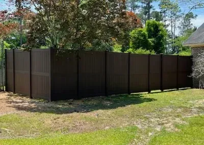 Brown privacy fence in a grassy backyard.