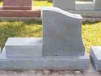 Gray granite headstone in a cemetery.