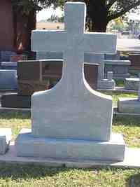Light gray stone cross headstone in a cemetery.