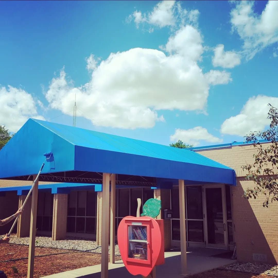 Small building with bright blue roof and red wall box under a cloudy sky