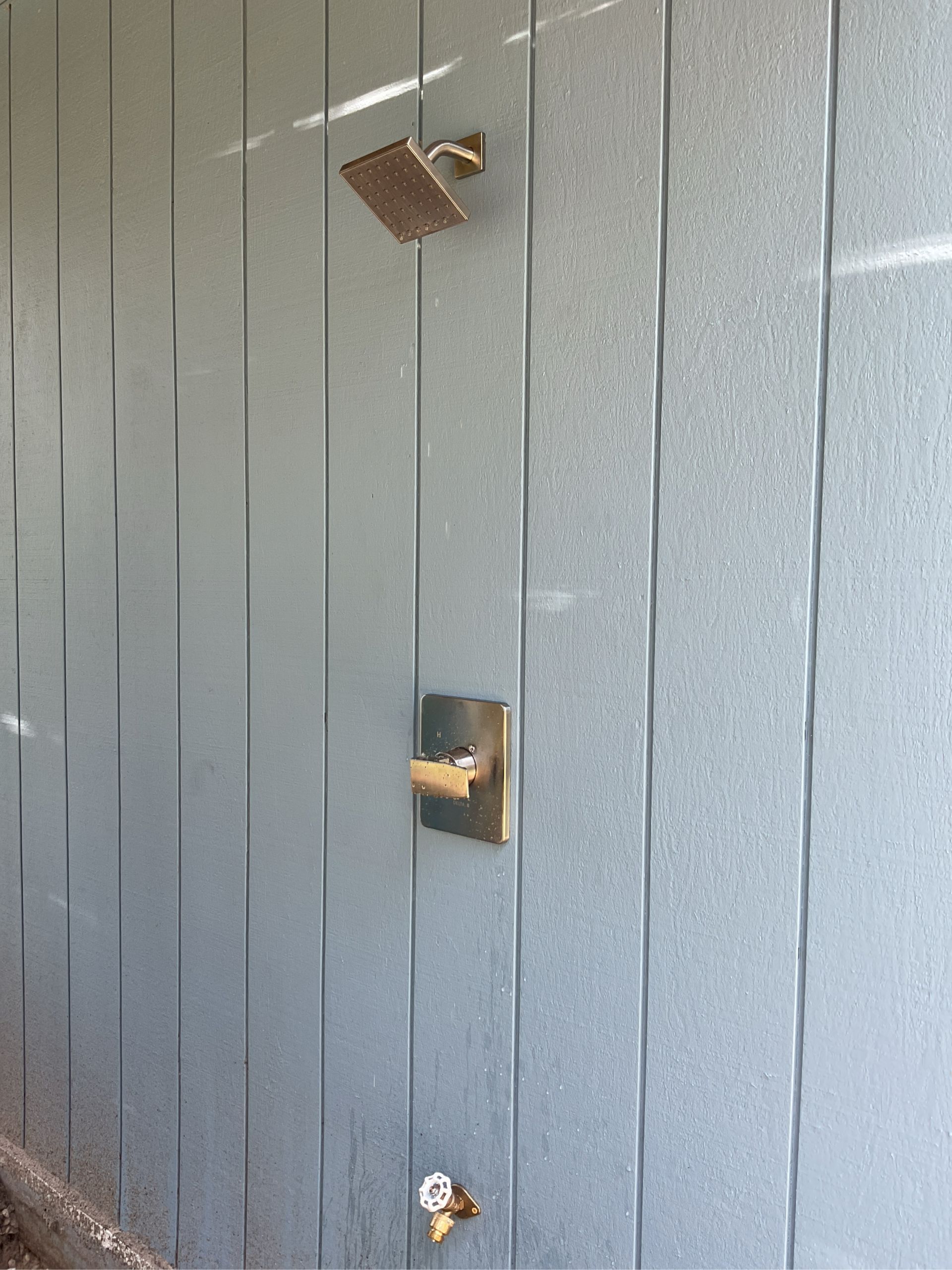 A shower head is hanging from the side of a wall.