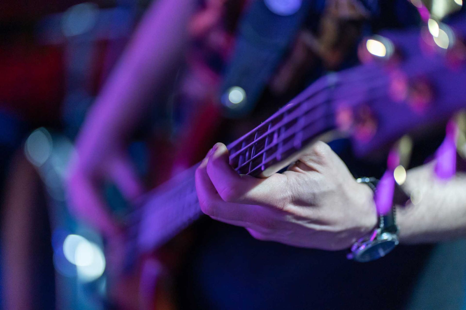 A person playing a bass guitar on a stage