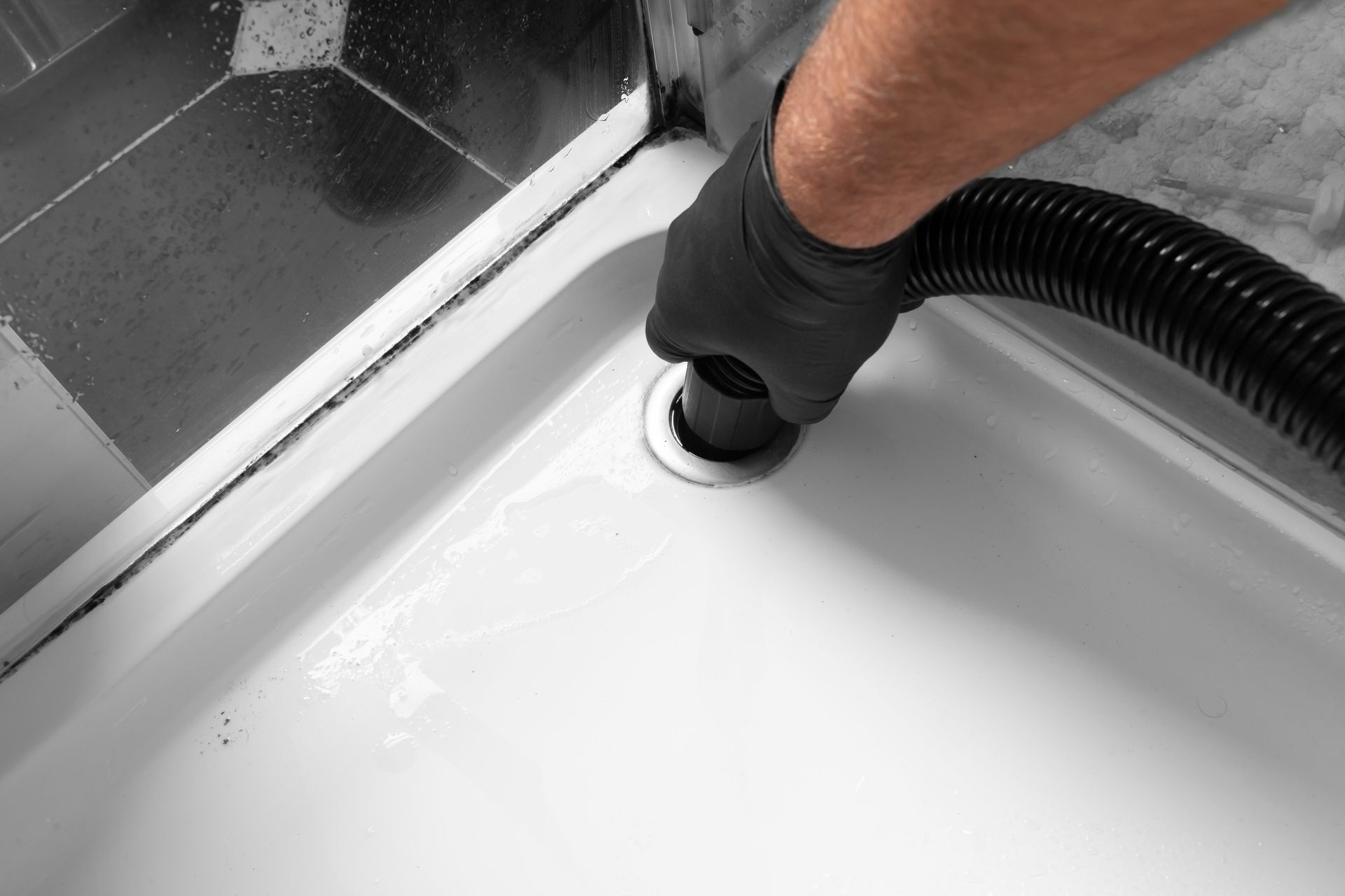 Plumber performing emergency drain cleaning on a clogged sink drain.