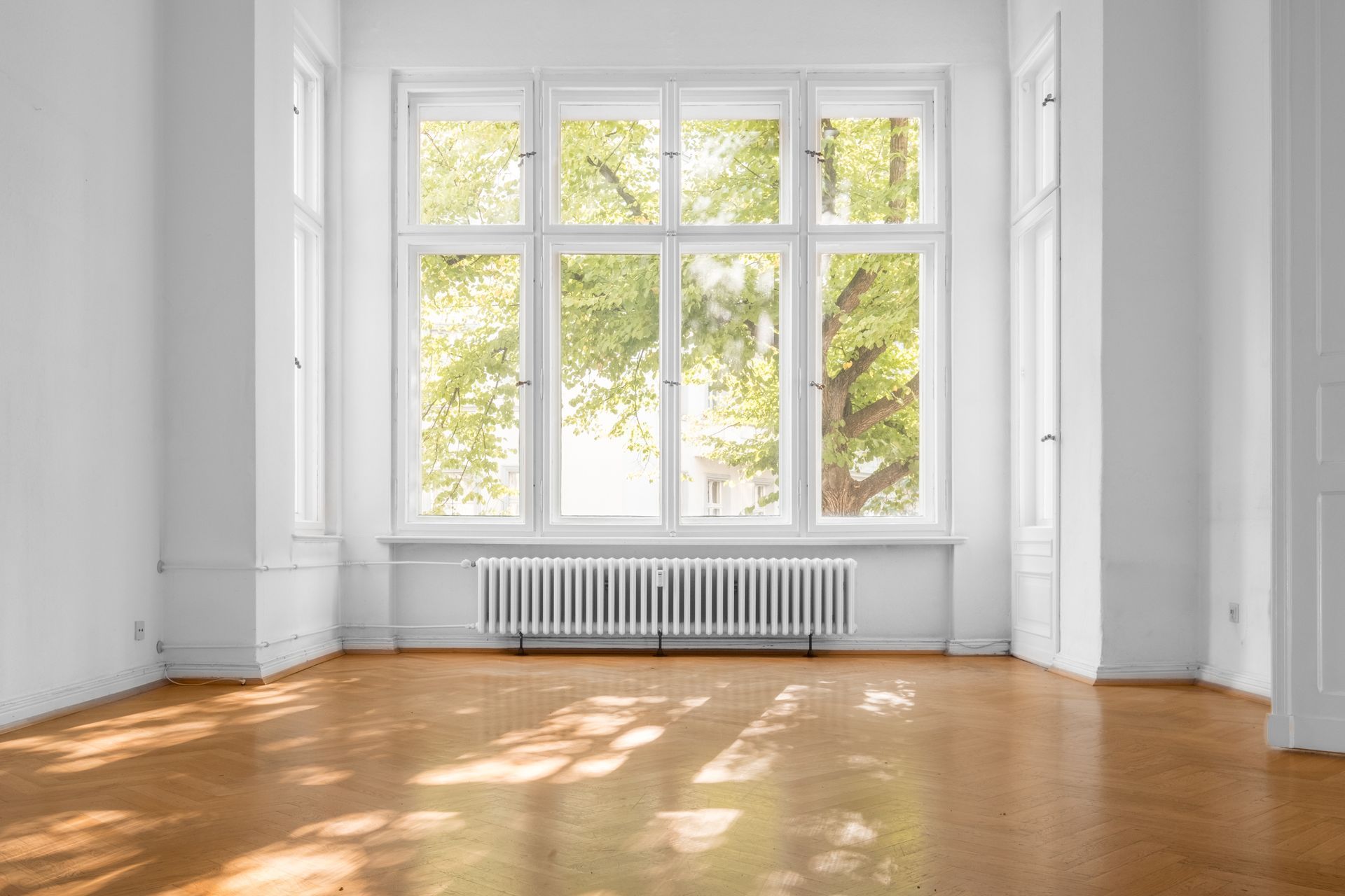 Window in an empty room of an old apartment building with parquet flooring