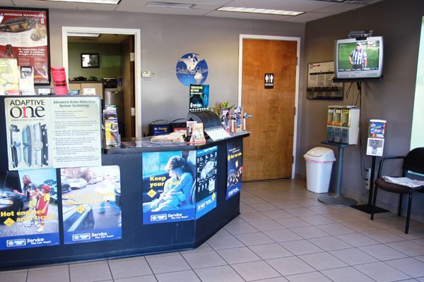 Movie theater lobby with ticket counter, posters, and a TV on the wall