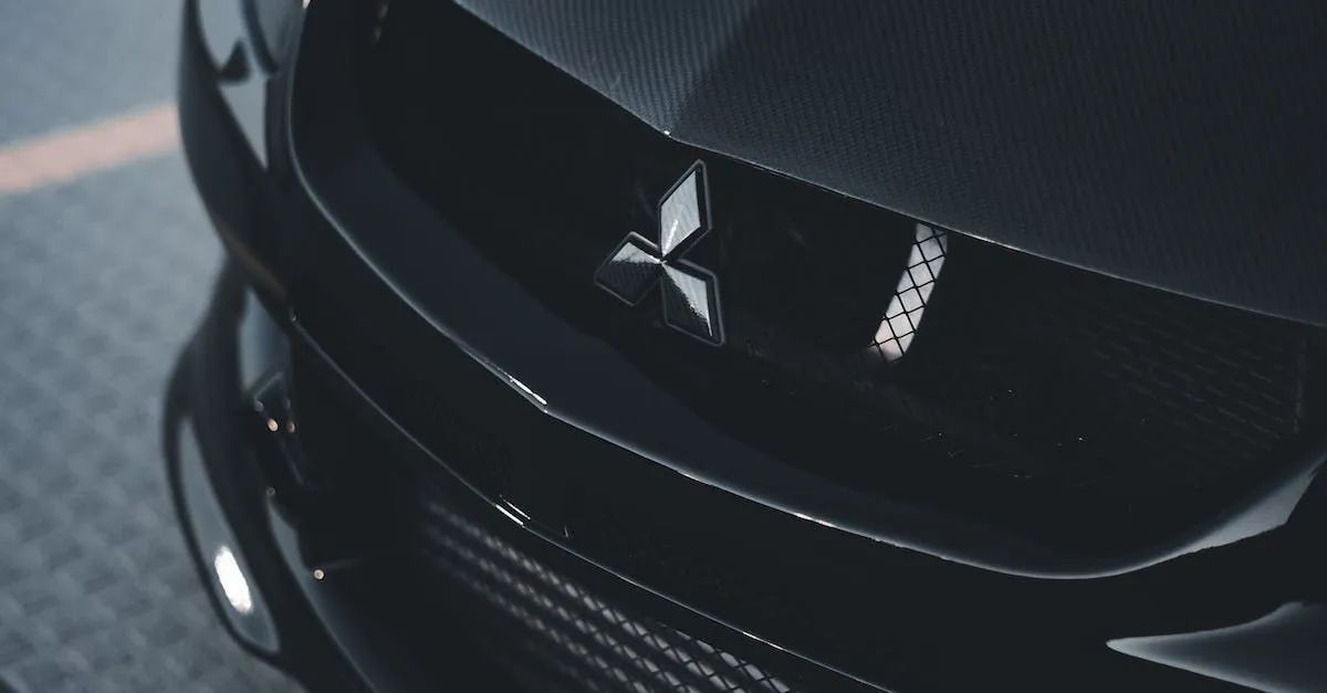 Close-up of a black Mitsubishi car grille with chrome emblem and headlights