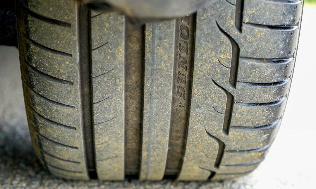 Close-up of two car tires, one worn smooth and one with deep tread, side by side.