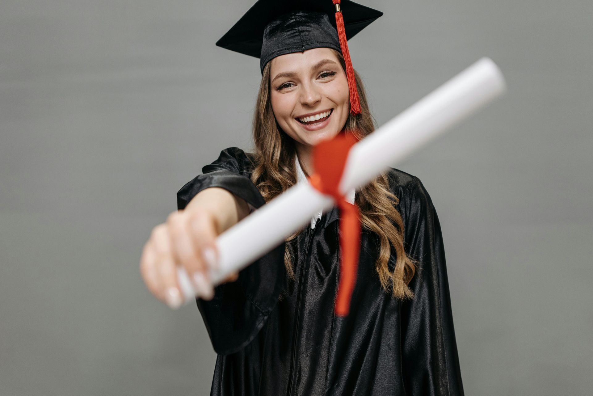High school student holding a diploma from an online school