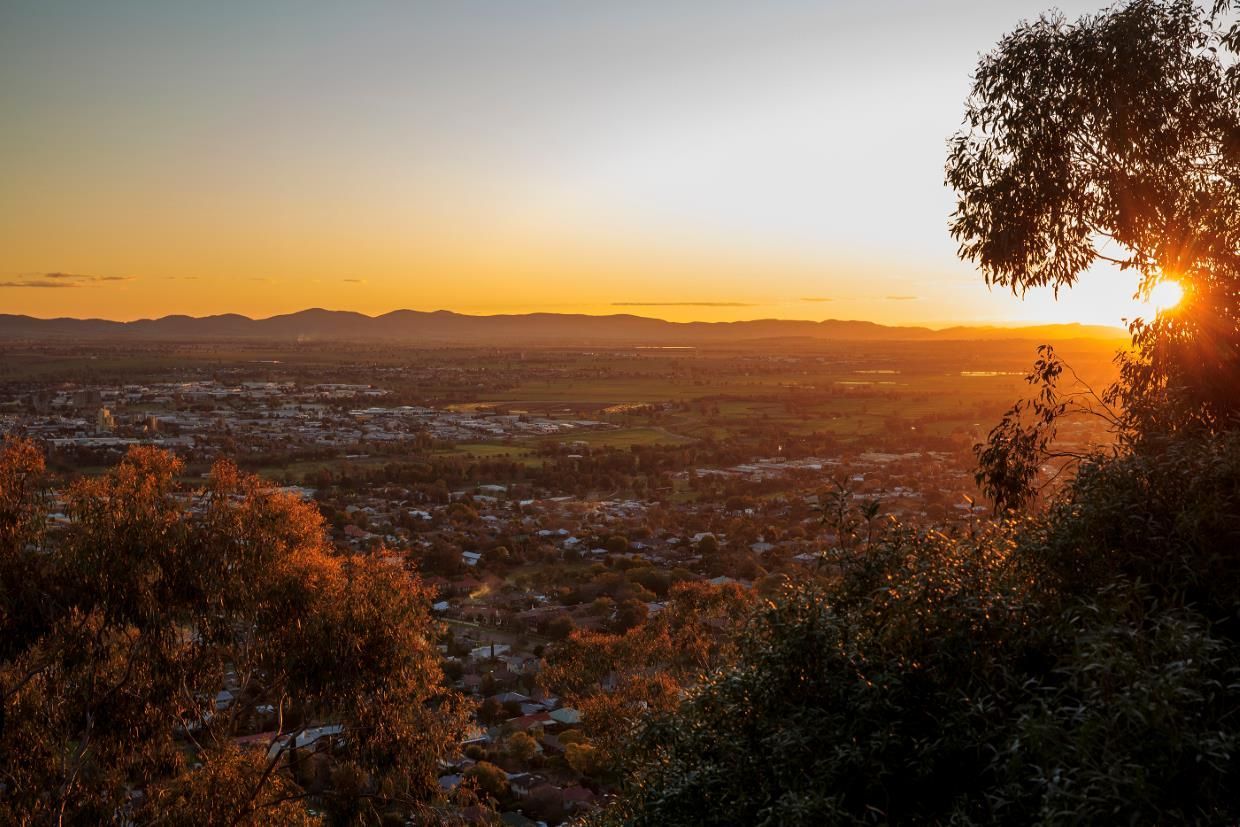The Sun is Setting Over a City Surrounded by Trees — North West Heating, Cooling and Refrigeration in Tamworth, NSW