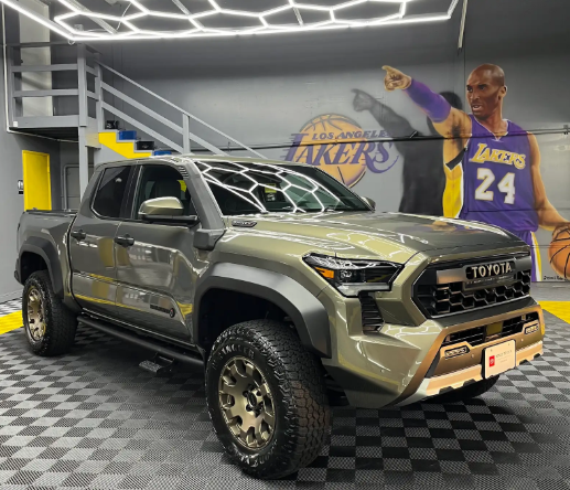 Gray Toyota SUV in a showroom, with a Lakers mural and Kobe Bryant figure in the background