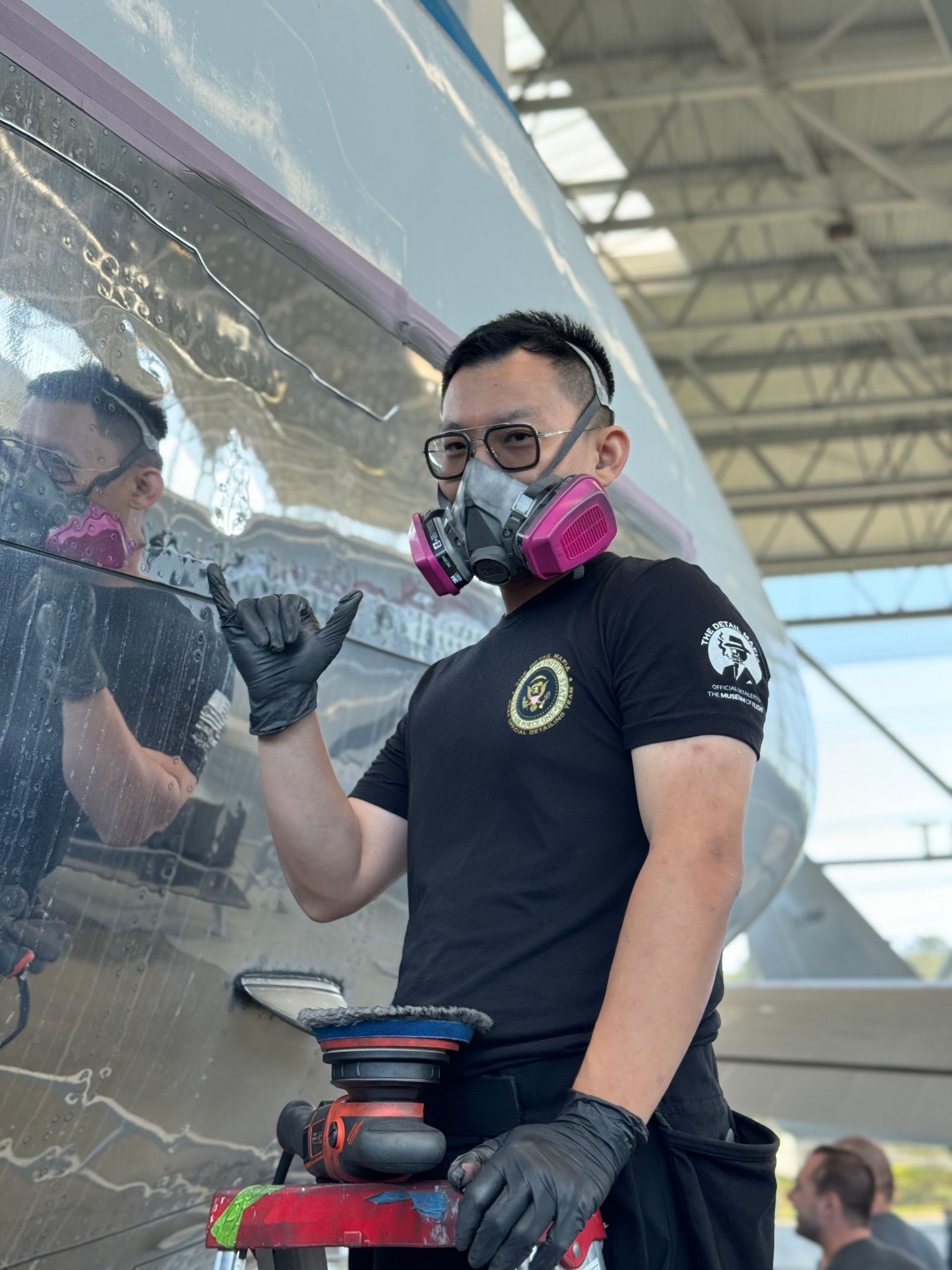A man wearing a mask is working on an airplane