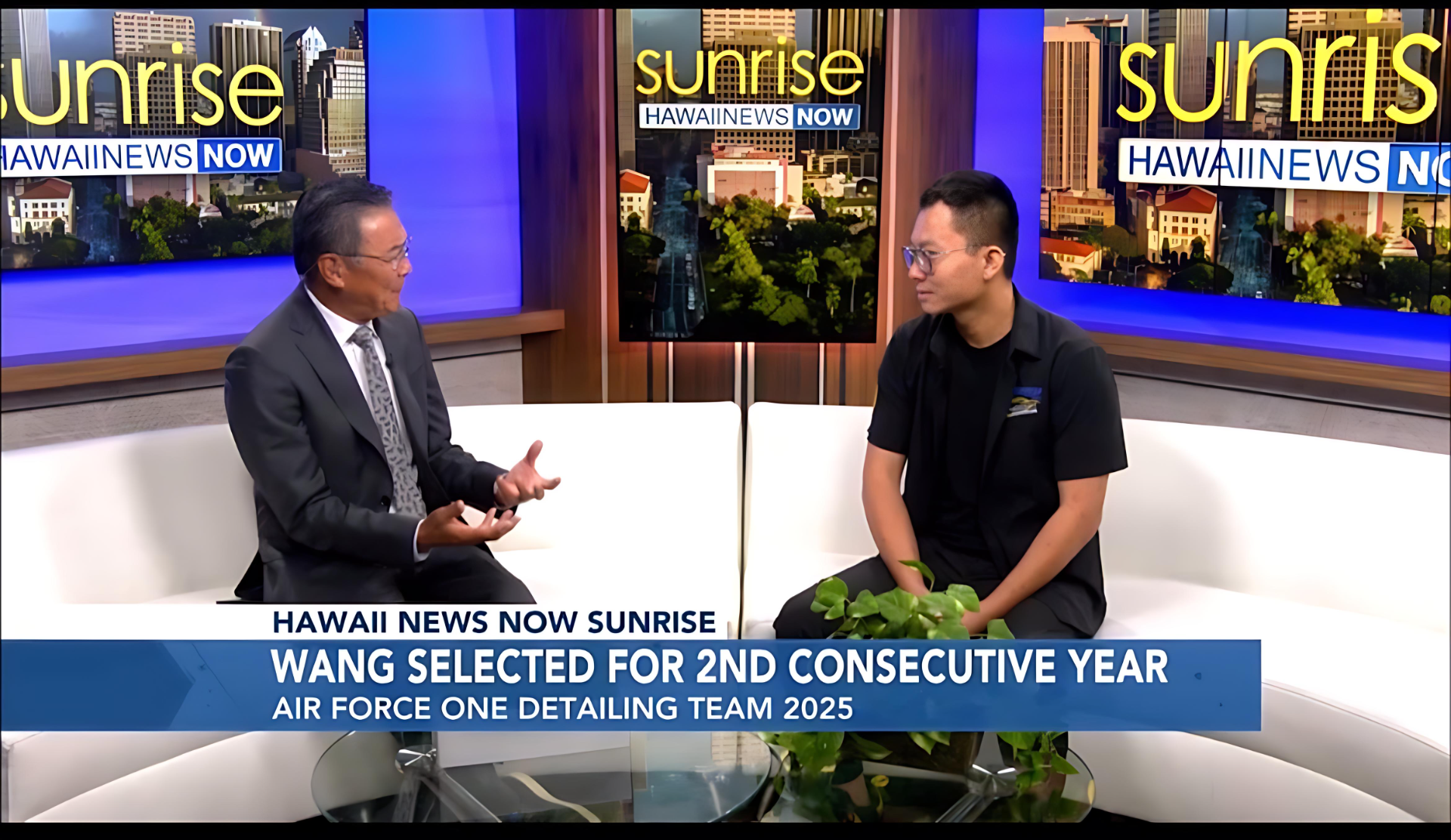 Two men are sitting on a couch in front of a screen that says sunrise