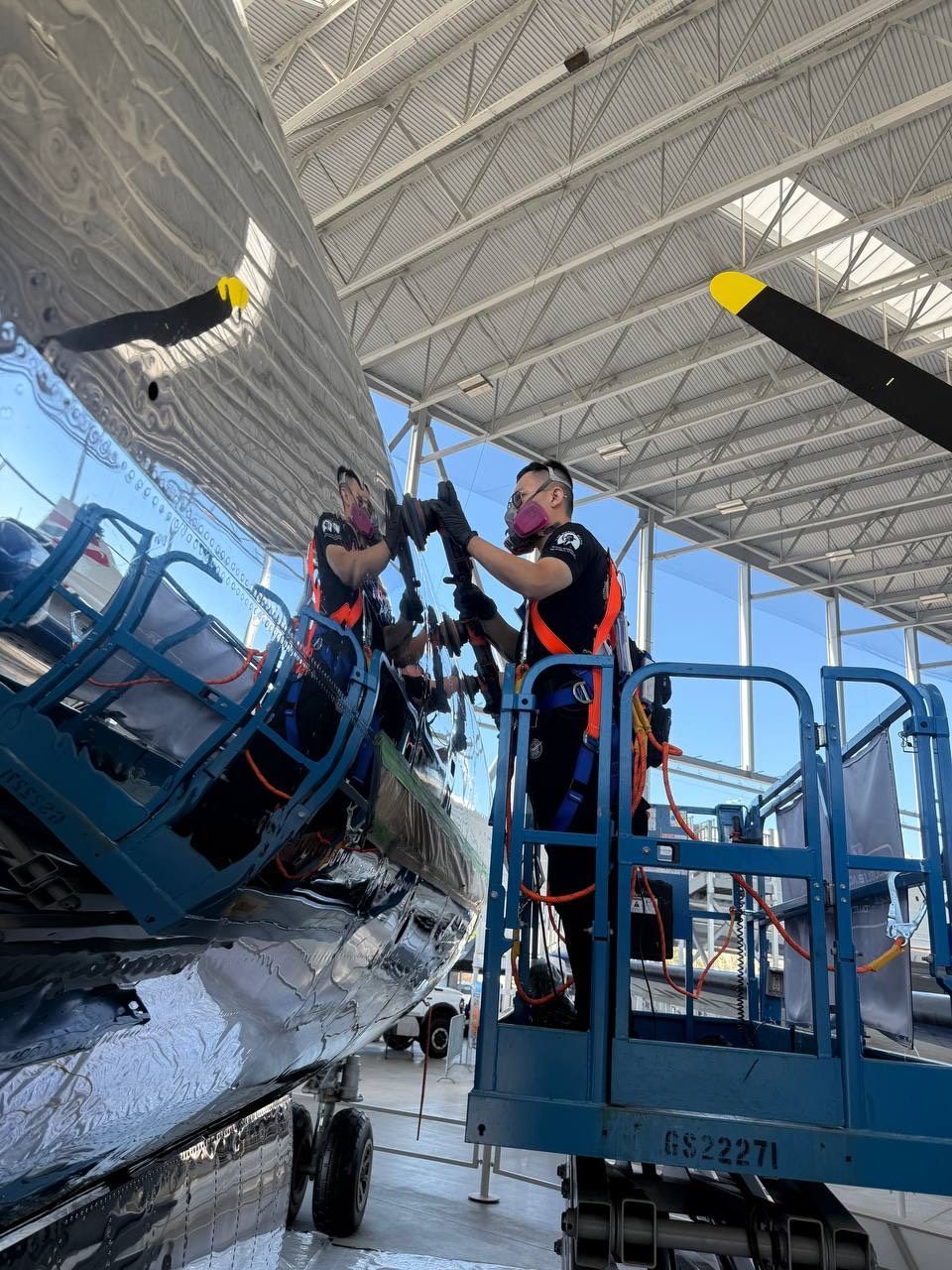 A group of men are working on a plane in a hangar.