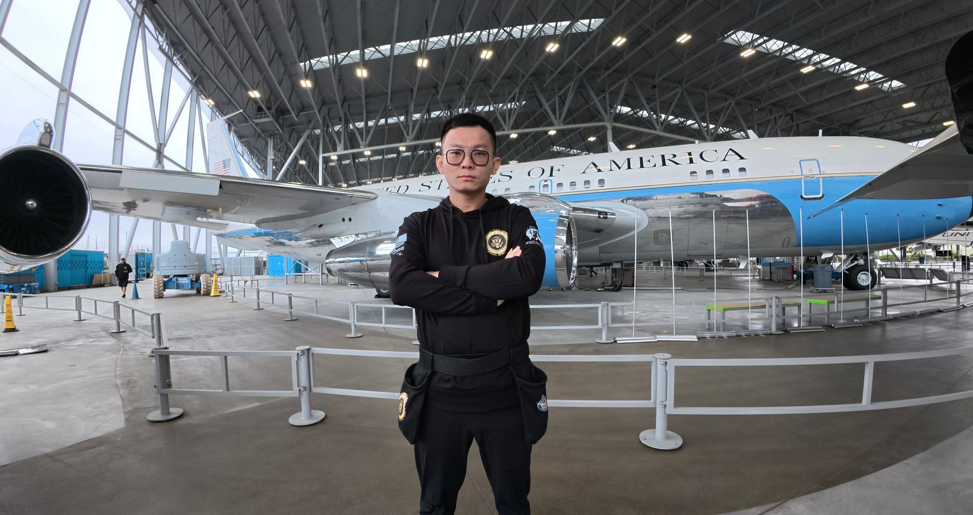 A man is standing in front of an airplane in a hangar.