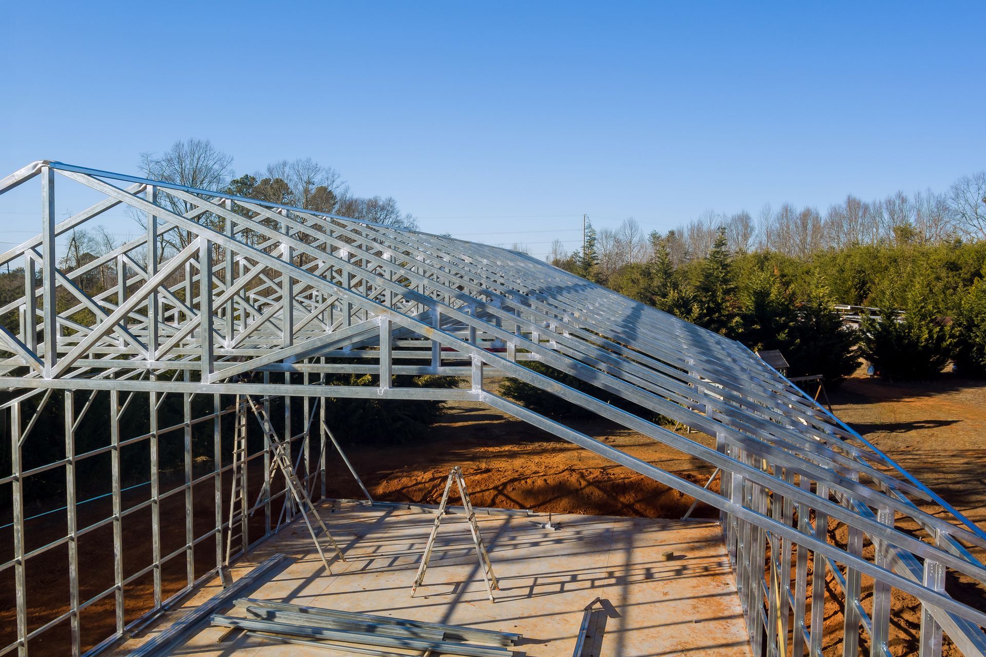Steel roof framing installed on a building under construction on a clear day. Steel roof framing installed on a building under construction on a clear day.