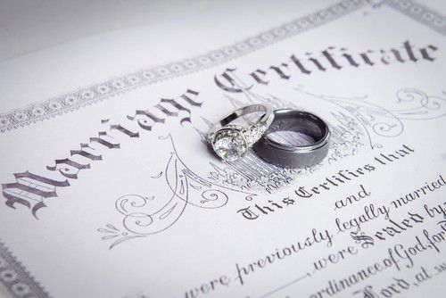 Marriage certificate with two wedding rings on a decorative document