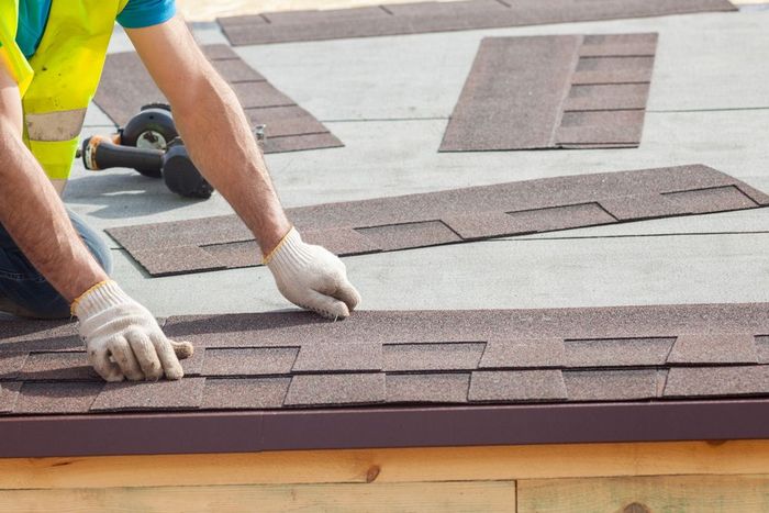 Professional Roof Worker Installing New Tile of Shingles
