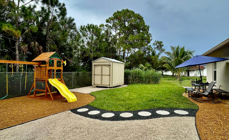 A backyard with a playground and a shed